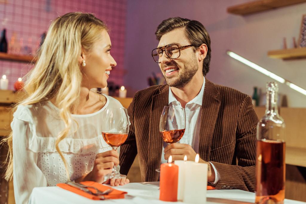 pareja con copas de vino celebrando y teniendo cita en mesa con velas en restaurante
  - Foto, imagen