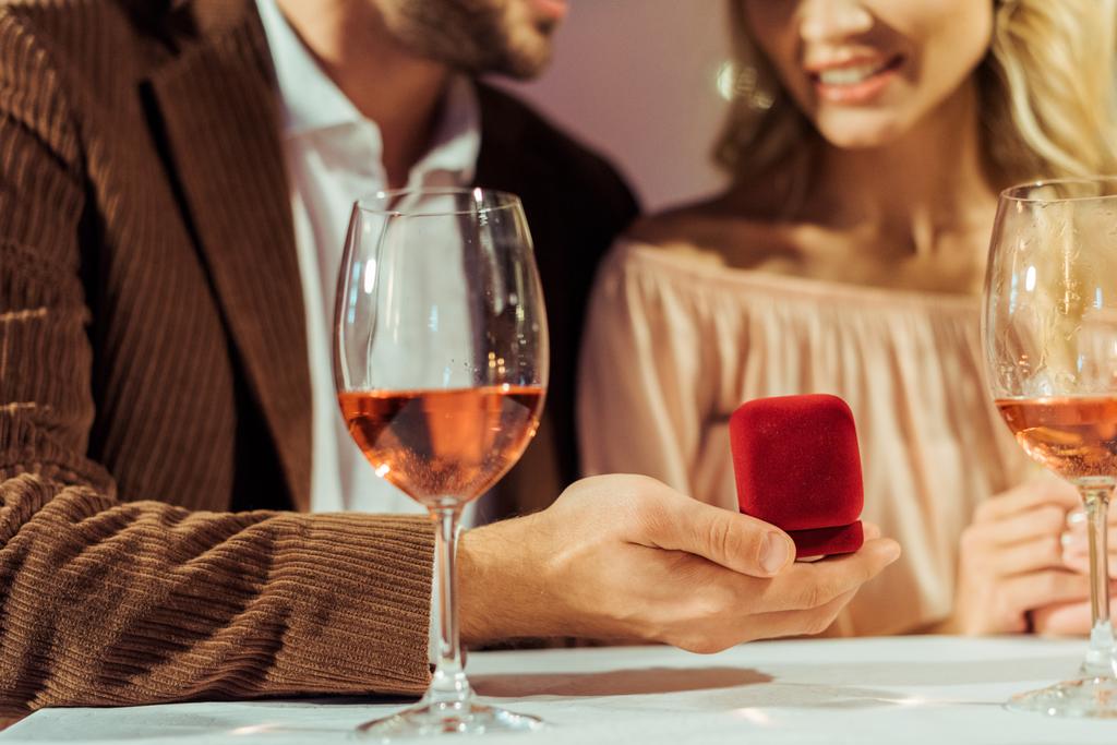 обрезанный образ мужчины, делающего предложение девушке во время романтического ужина в ресторане
  - Фото, изображение