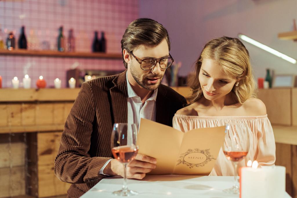 pár látszó-on étlap-romantikus vacsora alatt étteremben  - Fotó, kép