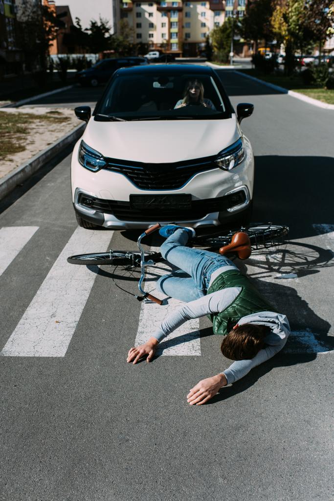 male bicycle rider hit by woman in car on road, car accident concept - Photo, Image
