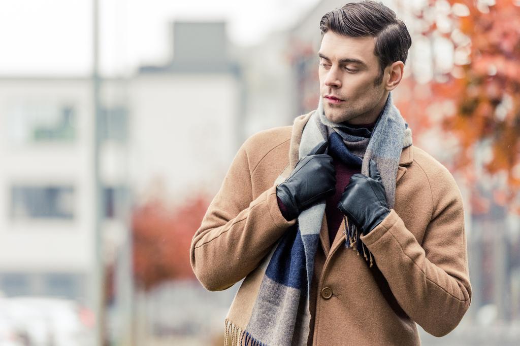 όμορφος άνδρας στο παλτό, δερμάτινα γάντια και κασκόλ που στέκεται στο δρόμο Φθινοπωρινό - Φωτογραφία, εικόνα