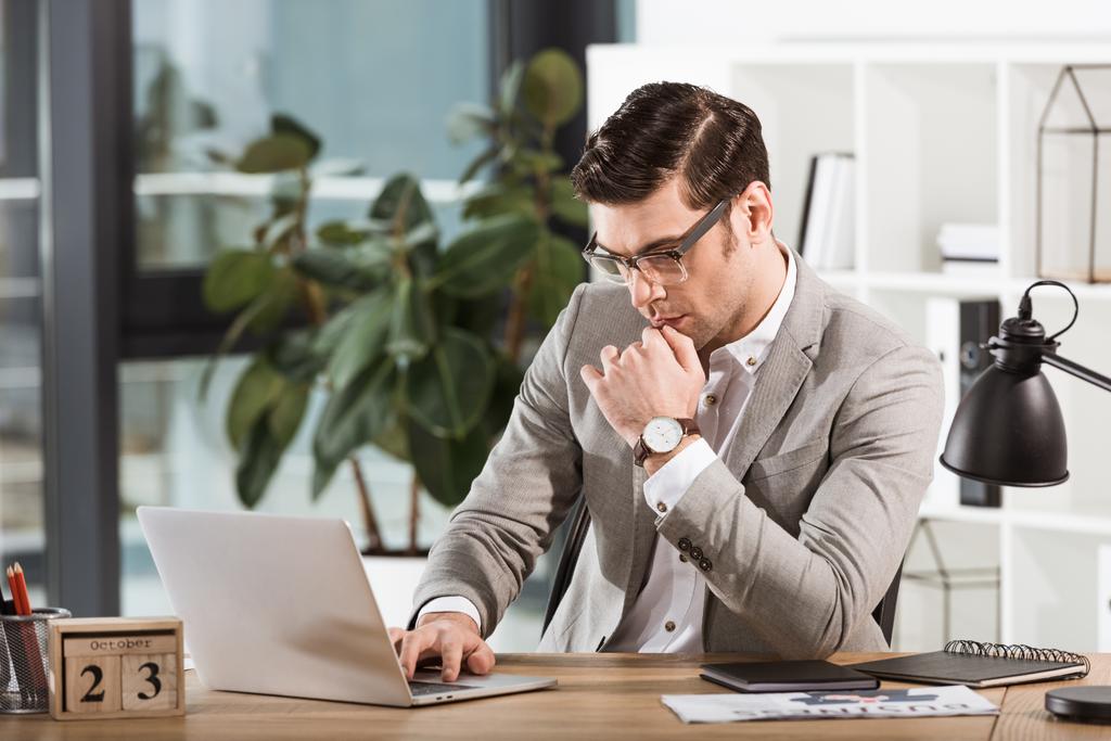 handsome focused businessman working with laptop at office - Photo, Image