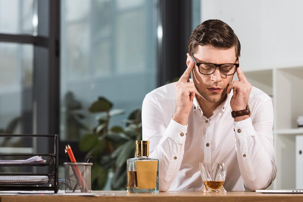 Überlasteter Geschäftsmann mit Glas Whiskey leidet unter Kopfschmerzen im Büro - Foto, Bild