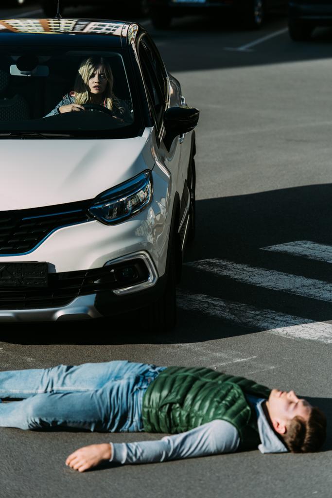車事故の後道路に横たわっている負傷した若い男のハイアングル  - 写真・画像