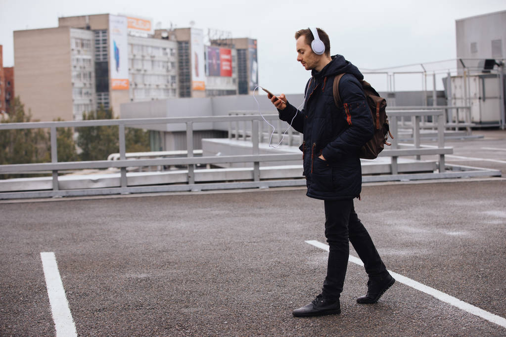 Ο άνθρωπος σε ακουστικά να ακούτε μουσική σε εξωτερικούς χώρους στην πόλη - Φωτογραφία, εικόνα