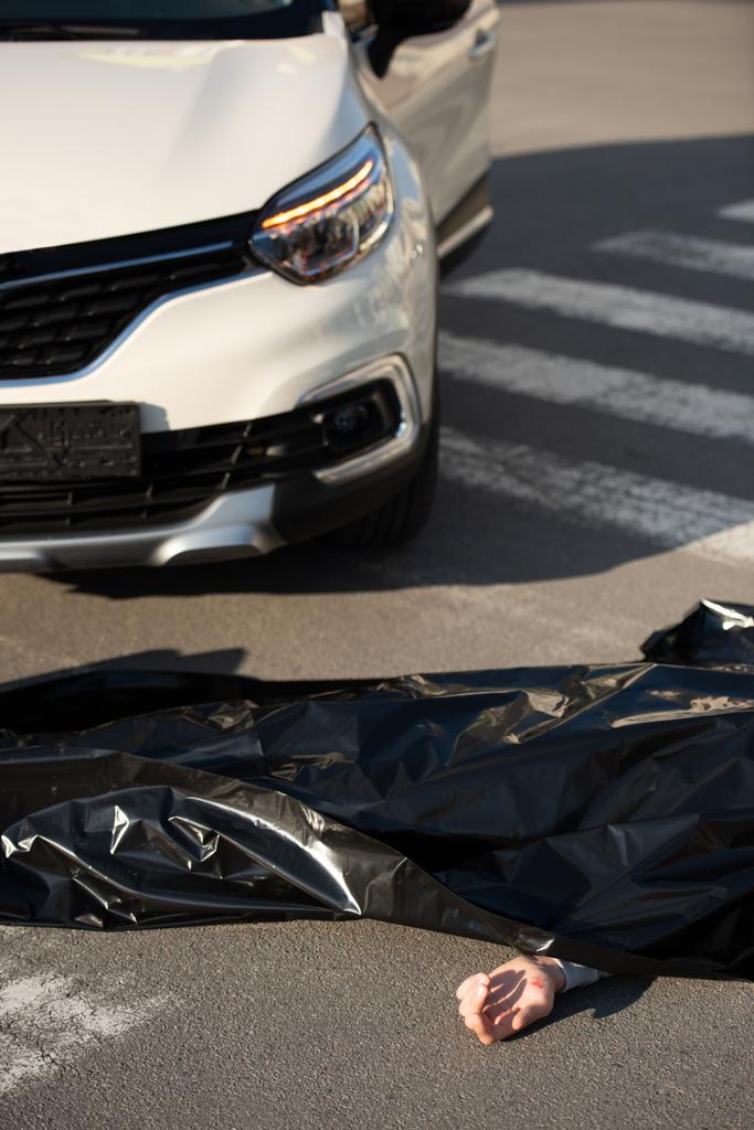 vista de ángulo alto del cadáver y el coche en la carretera después de la colisión de tráfico
 - Foto, imagen