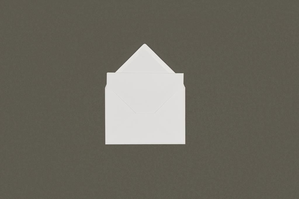 κάτοψη του άνοιγμα φάκελος Δίχρωμος Λευκός με κενή κάρτα που απομονώνονται σε γκρι  - Φωτογραφία, εικόνα