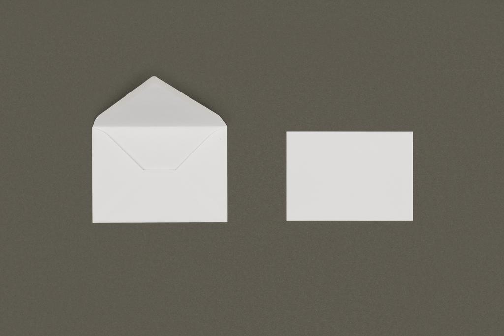 開いている白い封筒と灰色の背景に分離された空白のカードのクローズ アップ ビュー  - 写真・画像