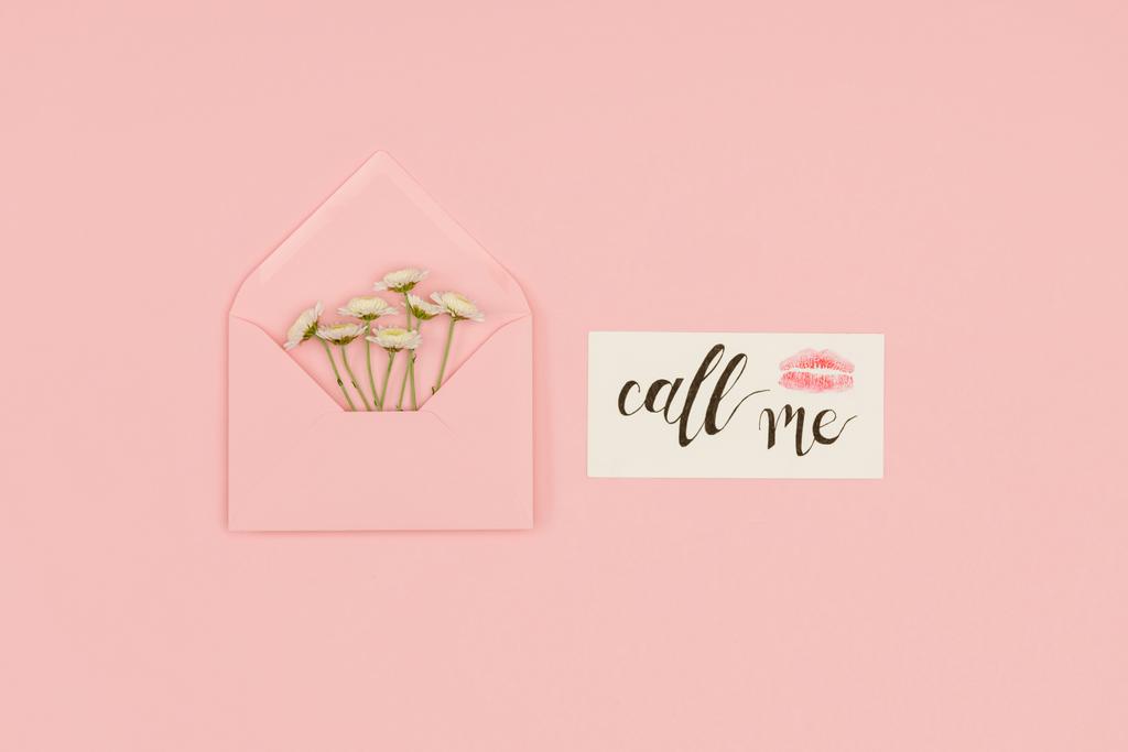 вид зверху на відкритий рожевий конверт з маленькими білими квітами, листівка з викликом мені напис і знак поцілунку ізольовані на рожевому
 - Фото, зображення