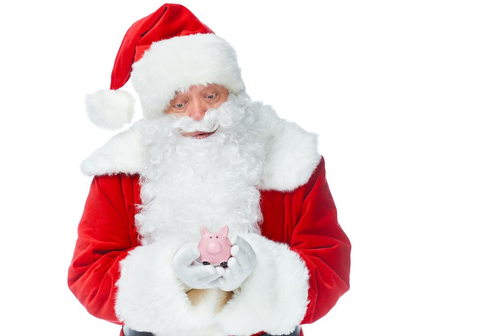 Santa claus houden weinig spaarvarken geïsoleerd op wit - Foto, afbeelding