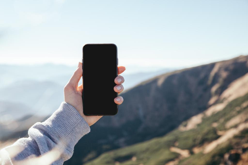 обрезанный снимок женщины, делающей фото горы со смартфоном с пустым экраном, Карпаты, Украина
 - Фото, изображение