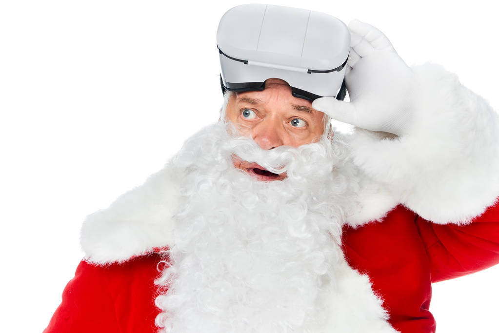 santa claus using virtual reality headset at christmastime isolated on white - Photo, Image