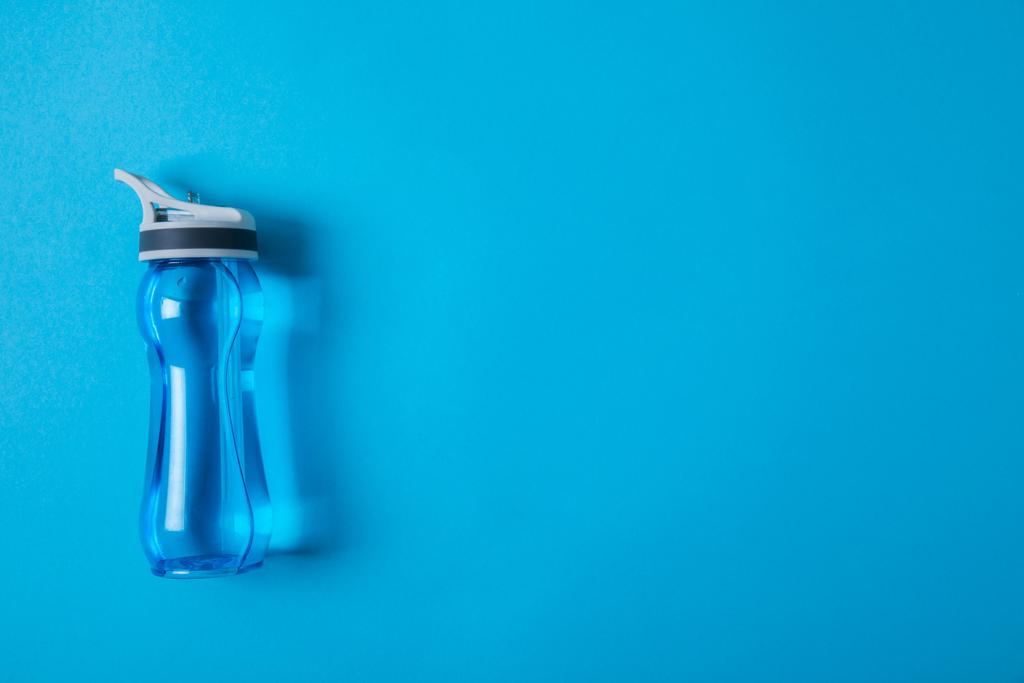 vista de cima de garrafa de esporte com água isolada em azul, conceito minimalista
  - Foto, Imagem