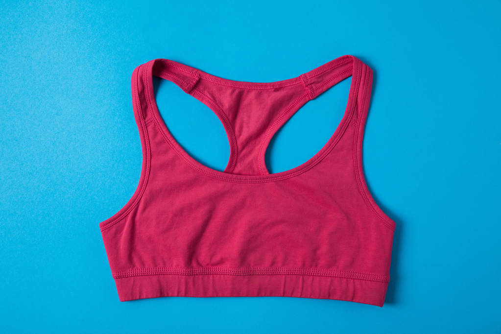 plat avec soutien-gorge de sport rose isolé sur bleu, concept minimaliste
  - Photo, image