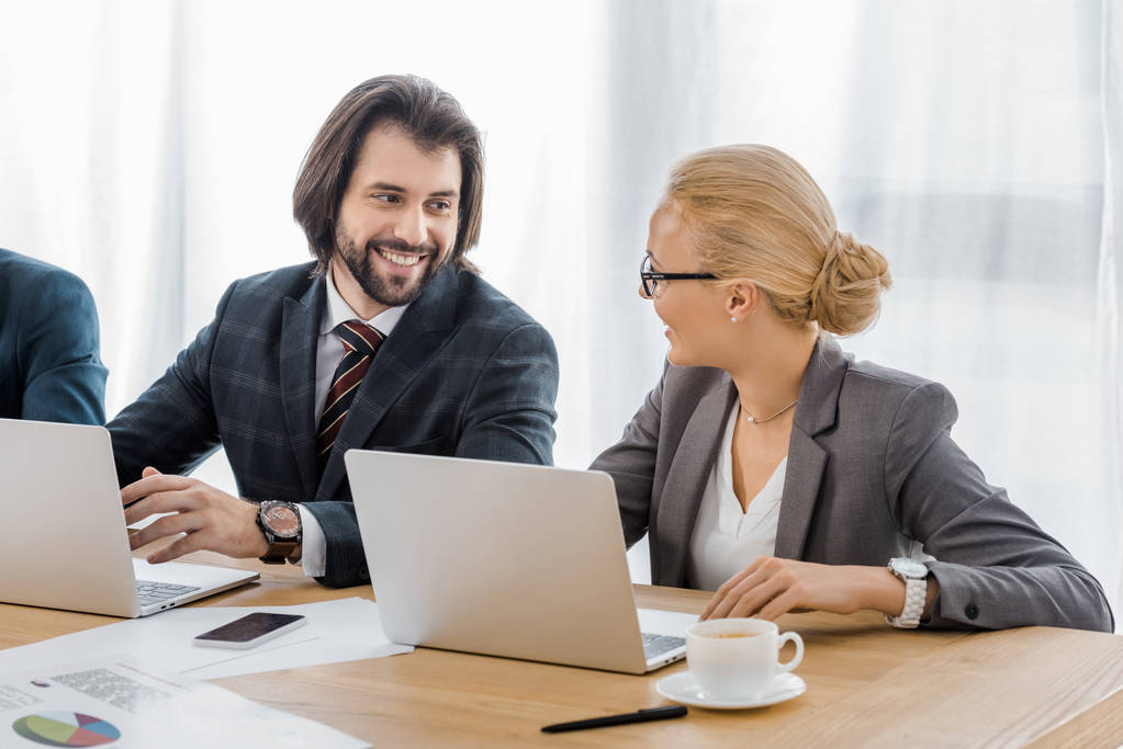 улыбающиеся деловые люди, говорящие на встрече в офисе
 - Фото, изображение