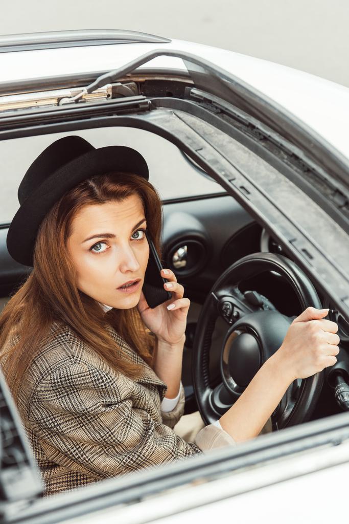 portret stylish woman czarny kapelusz mówić na smartfonie siedząc przy kierownicy w samochodzie - Zdjęcie, obraz