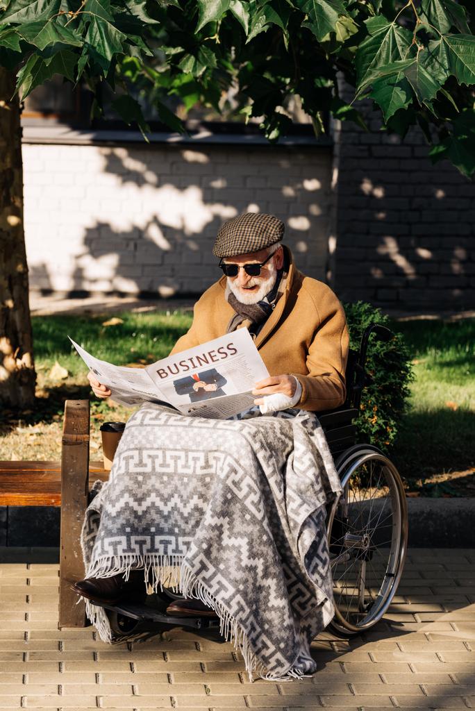高齢者が車椅子路上ビジネス新聞を読む男を無効に - 写真・画像
