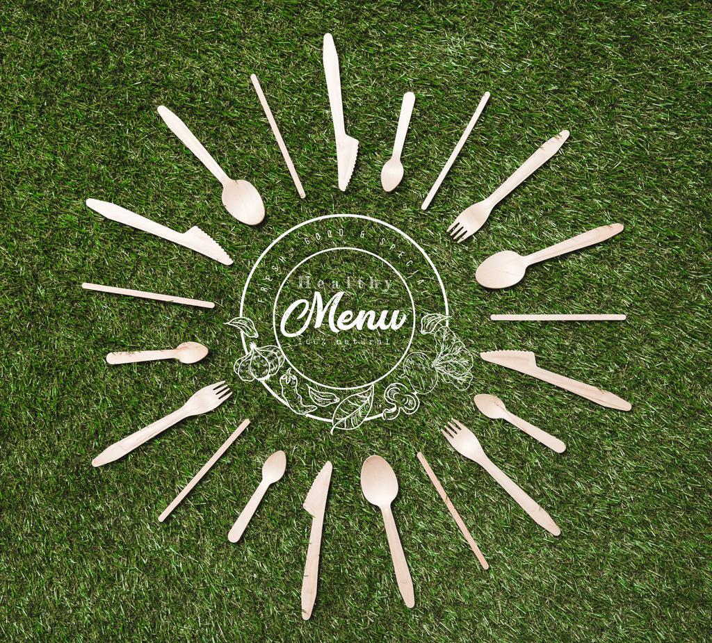 Widok góry drewniane łyżki, widelce i noże w kształcie słońca leżąc na trawie, napis menu - Zdjęcie, obraz