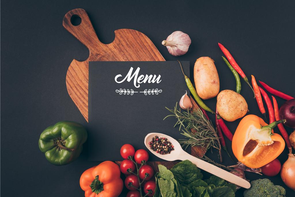 felülnézete a szürke tábla fekete karton menü betűkkel a fából készült asztal zöldségekkel - Fotó, kép