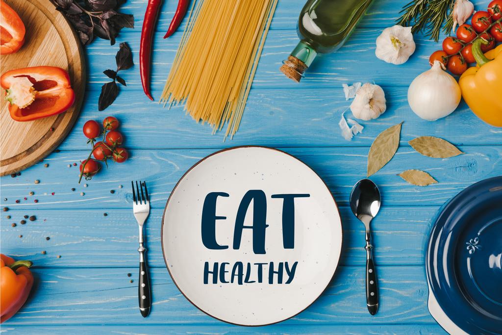 pohled z přísad pro vaření těstovin na modrém stole shora, jíst zdravé nápis - Fotografie, Obrázek
