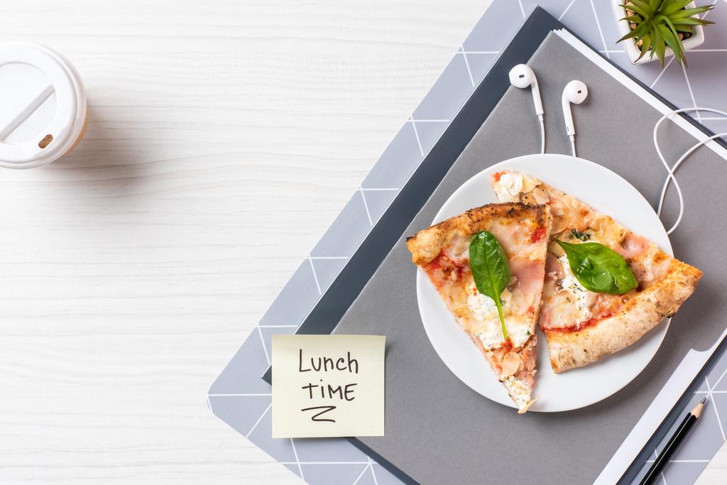 κάτοψη του κολλώδη σημείωση με επιγραφή ώρα του μεσημεριανού, ακουστικά και πίτσα στο τραπέζι - Φωτογραφία, εικόνα