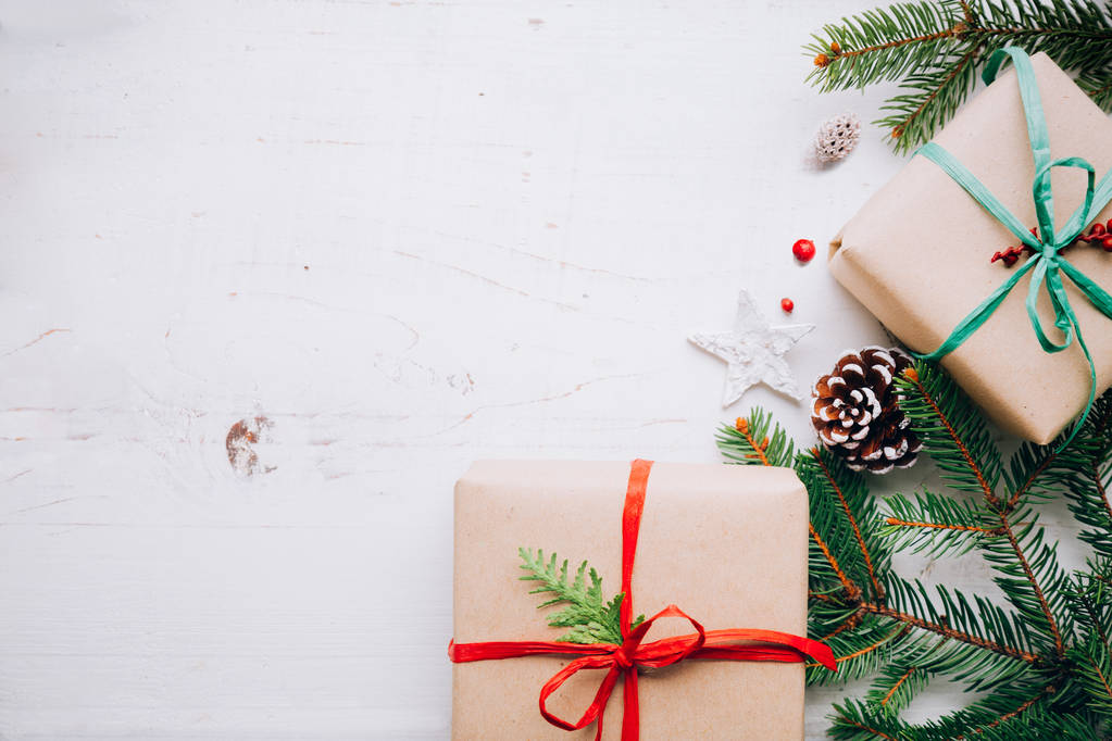 Vánoční dárky s vystřihovánek, pletený luky, jedle větve přišít kužely a červené bobule bílý dřevěný stůl. Ležel plochý, kopie prostor - Fotografie, Obrázek