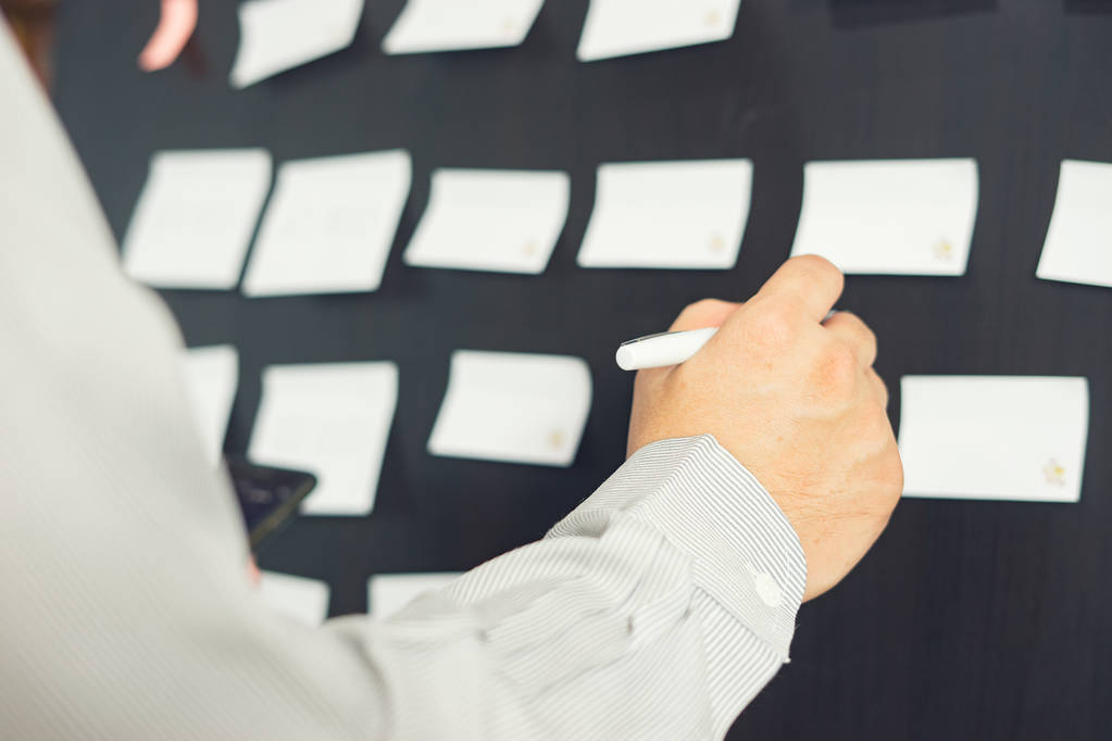 обрезанный образ бизнесмена, помещающего идеи на доску во время презентации в конференц-зале
 - Фото, изображение