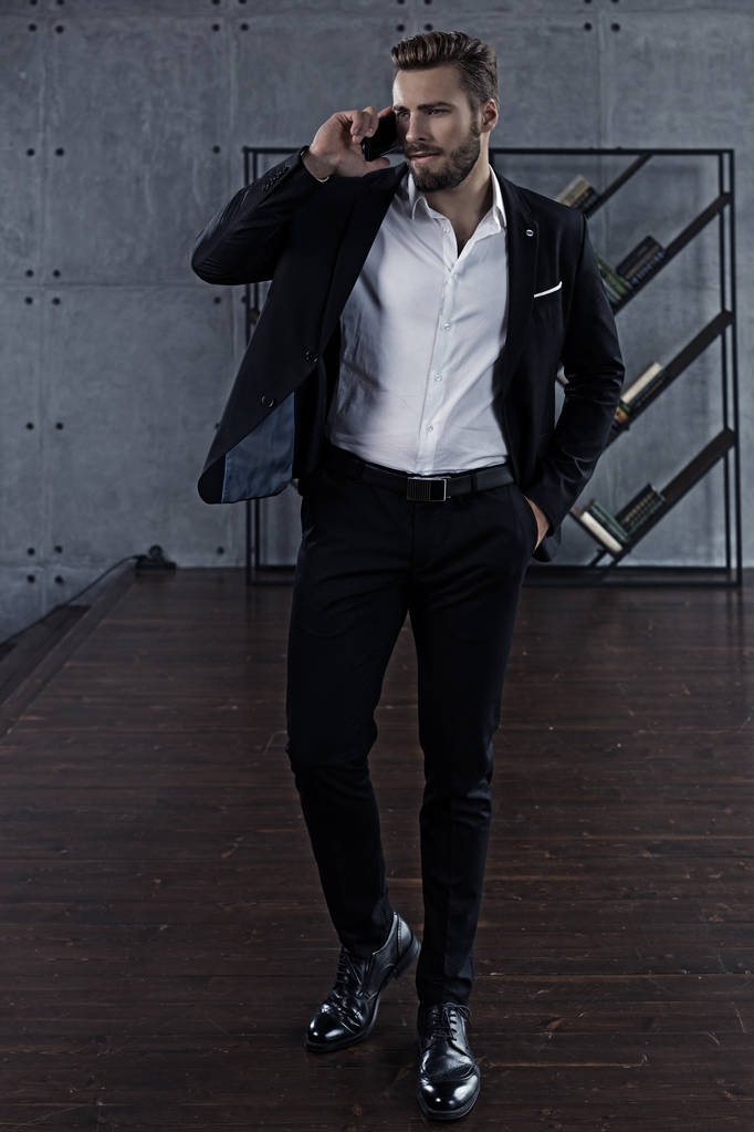 Biznesowe rozmowy na telefon komórkowy przystojny mężczyzna w czarnym garniturze - Zdjęcie, obraz