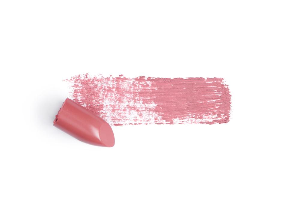 Draufsicht auf rosa Lippenstift-Strich auf weißem Hintergrund - Foto, Bild