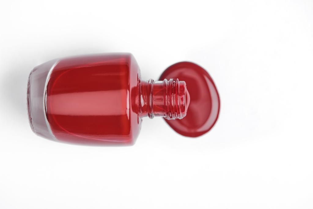 верхний вид красного лака для ногтей и бутылки на белом фоне
 - Фото, изображение
