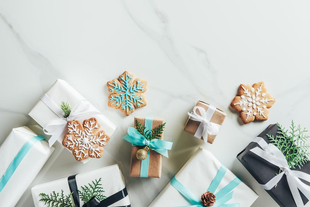 επίπεδη lay με κουτιά δώρου Χριστουγέννων και Μπισκότα χιονονιφάδες σε μαρμάρινο φόντο με αντίγραφο χώρου - Φωτογραφία, εικόνα