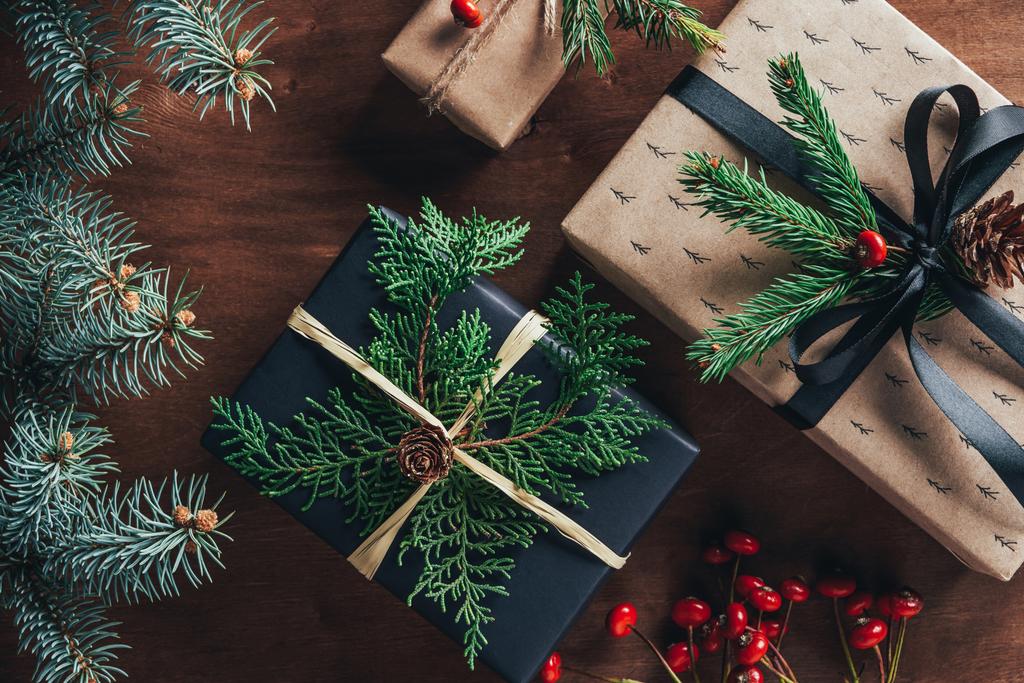 vue du dessus des coffrets cadeaux de Noël avec branches de sapin et baies décoratives sur fond en bois
   - Photo, image