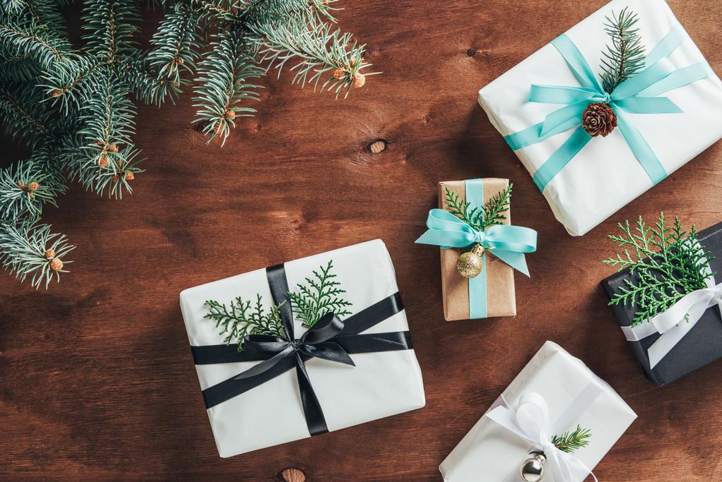felülnézet karácsonyi ajándék dobozok, fenyő fa ágai és dekoráció fából készült háttér - Fotó, kép