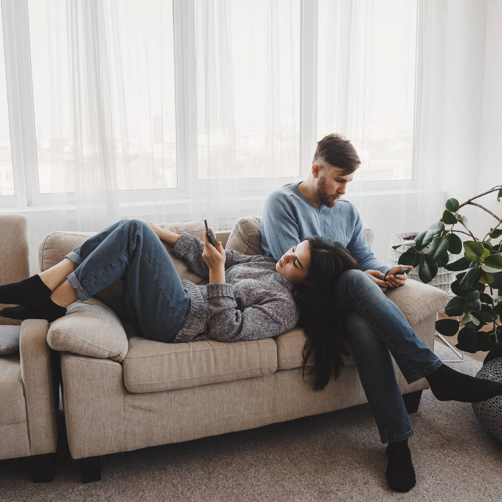 Paar im Wohnzimmer von Smartphones besessen - Foto, Bild