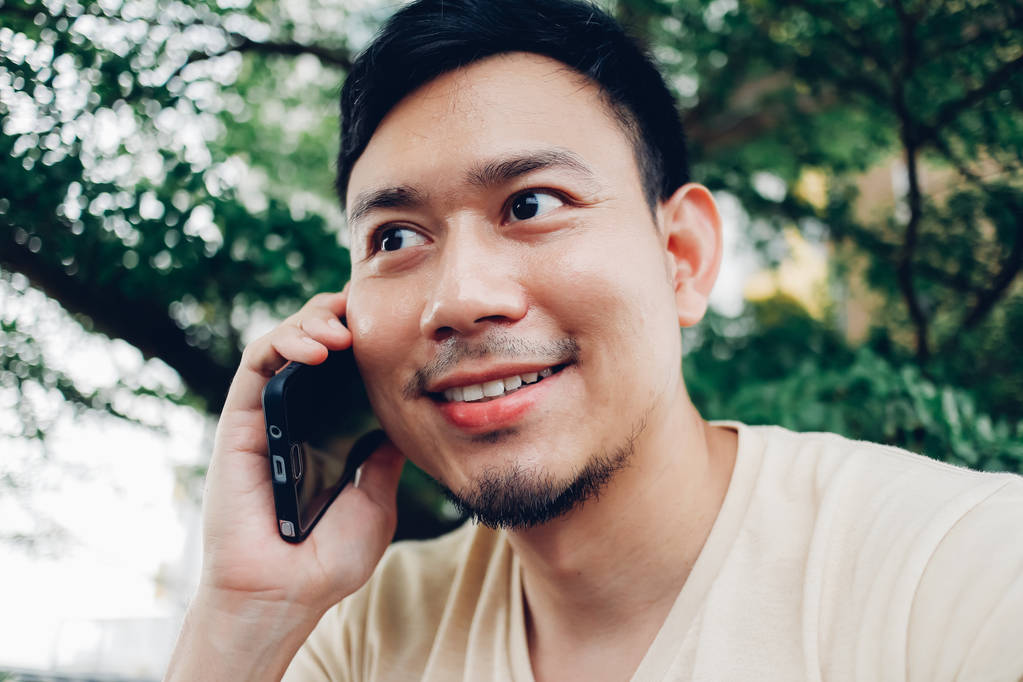 Homem asiático feliz tem uma conversa no smartphone
. - Foto, Imagem