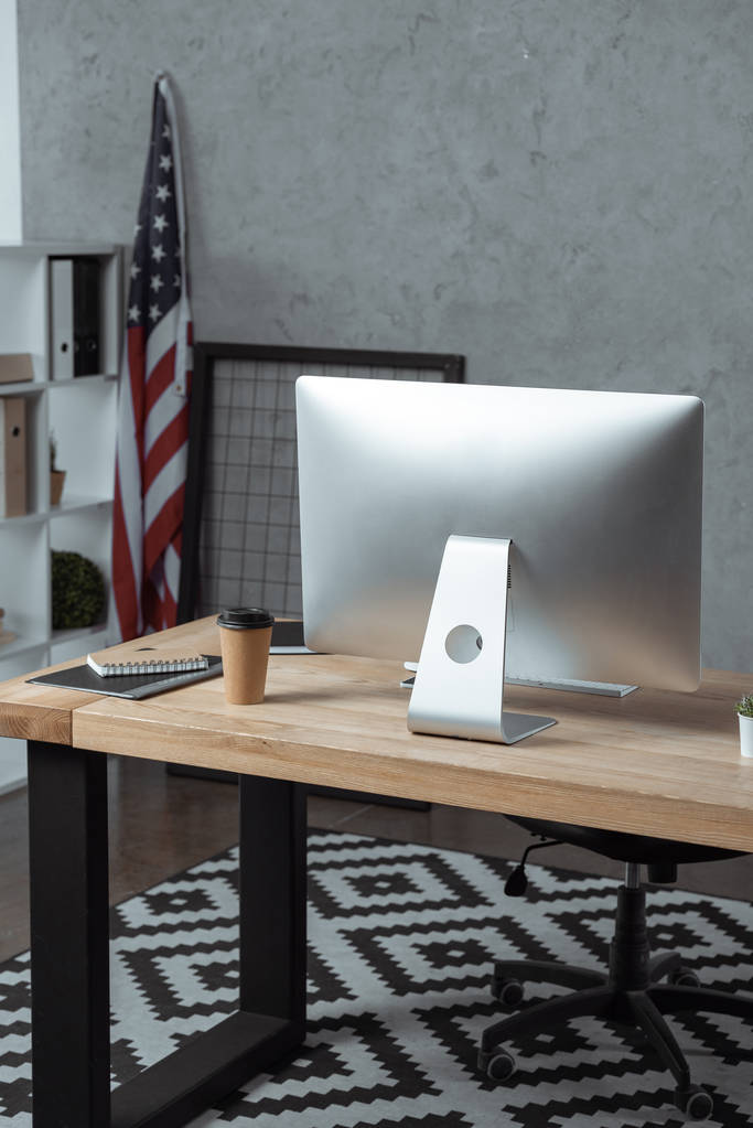 избирательный фокус рабочего места с одноразовой чашкой кофе и компьютерным монитором в современном офисе
  - Фото, изображение