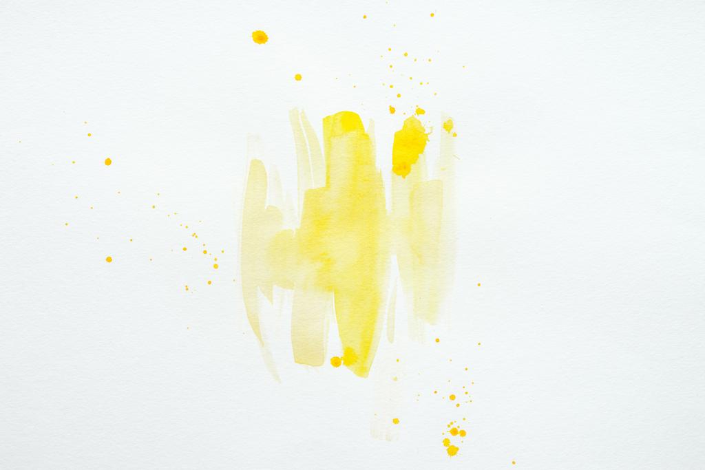 abstracte gele aquarel splatters op wit papier achtergrond - Foto, afbeelding