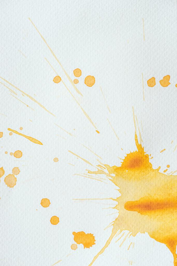 Artystyczny pomarańczowy akwarela splatters i plam na białym papierze - Zdjęcie, obraz