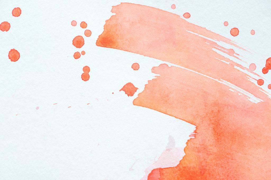 abstrakte rote Aquarellstriche und Spritzer auf weißem Papier - Foto, Bild