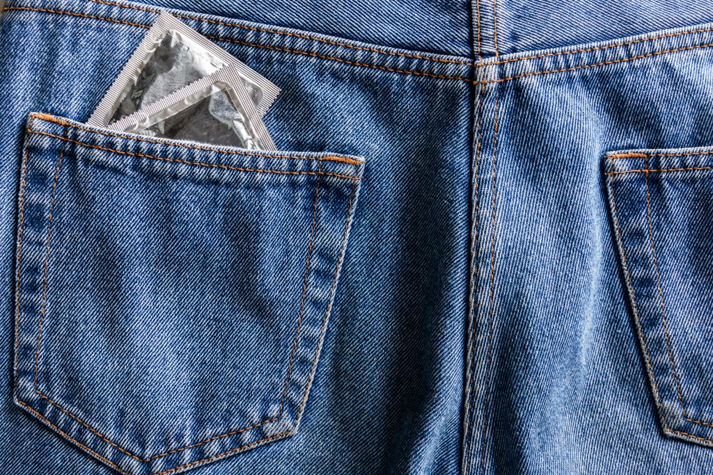 Paar silberne Kondome in der Tasche einer blauen Jeans - Foto, Bild