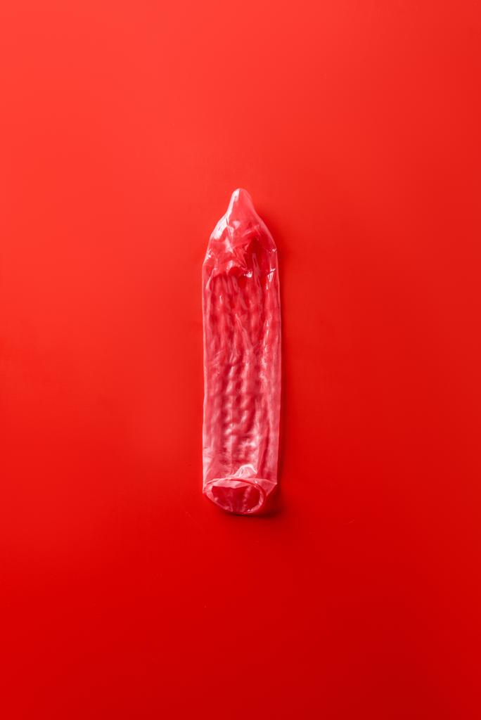 top view of red condom on red background - Photo, Image