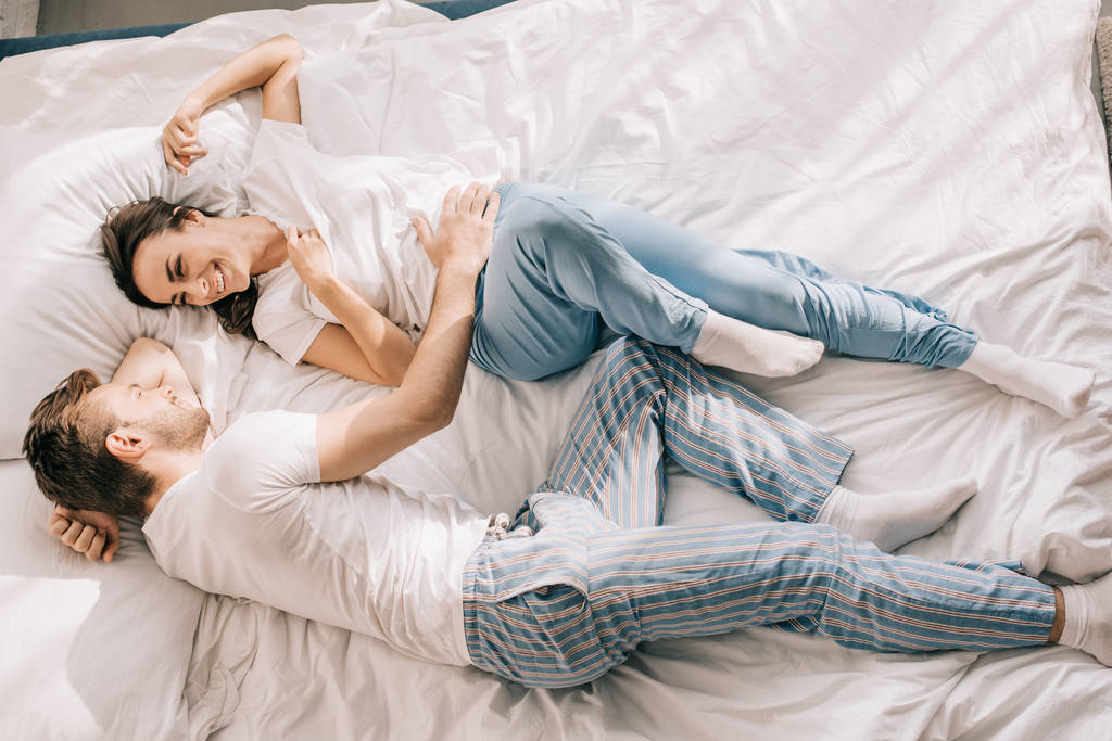gyönyörű fiatal pár szórakozik az ágyban reggel felülnézet - Fotó, kép