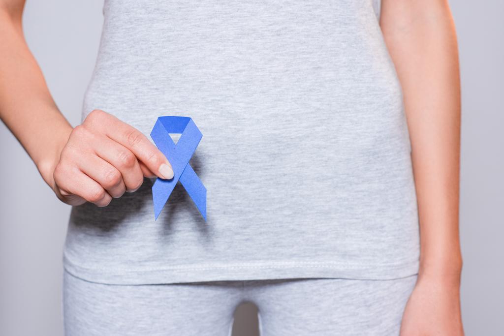 osittainen näkymä naisen tilalla eturauhassyöpä tietoisuus sininen nauha kädessä harmaalla taustalla
 - Valokuva, kuva