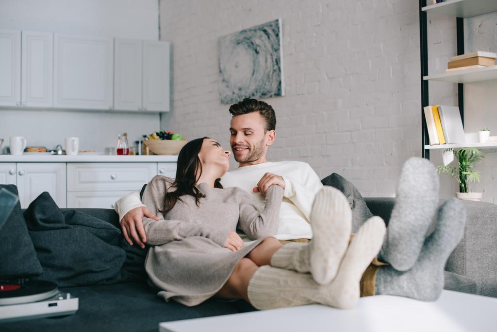 boldog pár gyapjú zokni, pihentető a kanapén, otthon - Fotó, kép