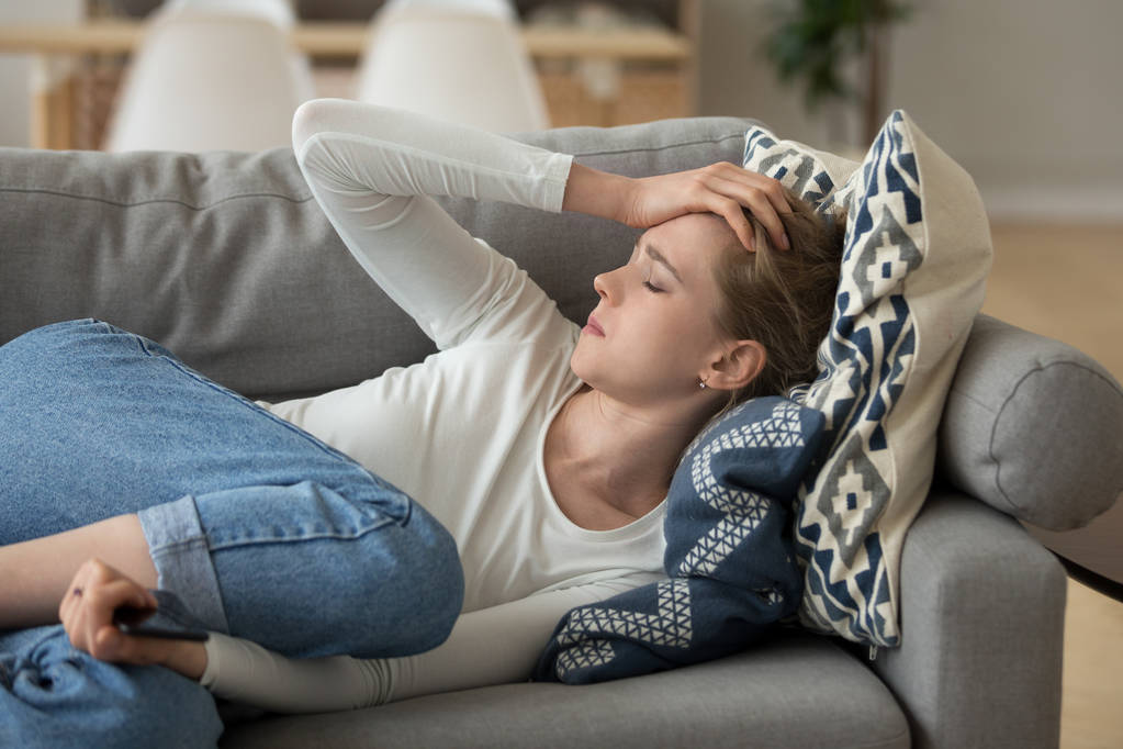 Mujer infeliz acostada en el sofá en casa
 - Foto, Imagen