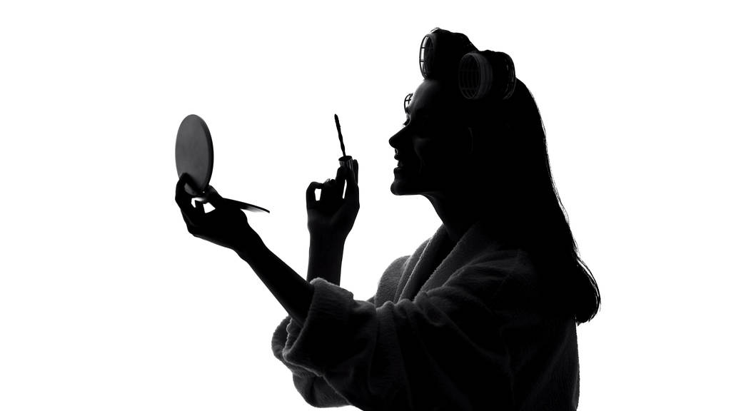 Ελκυστική νεαρή γυναίκα εφαρμογή μακιγιάζ μάσκαρα μπροστά από καθρέφτη, ομορφιά - Φωτογραφία, εικόνα