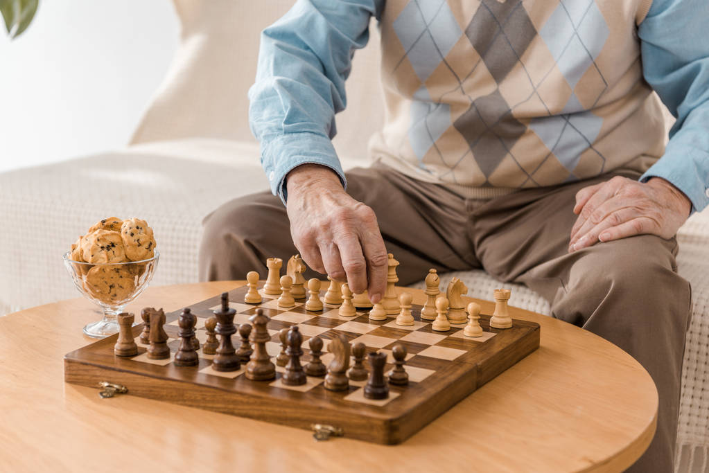 Nahaufnahme eines älteren Mannes, der auf dem Sofa sitzt und Schach spielt - Foto, Bild