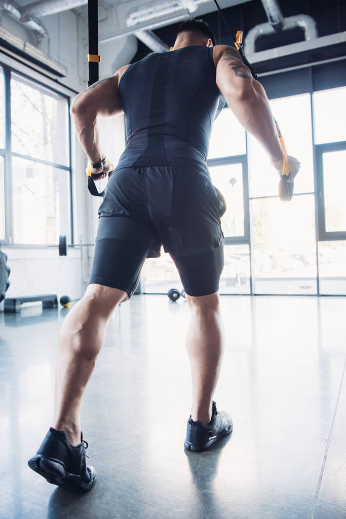 молодий м'язистий спортсмен тренування з смугами опору в тренажерному залі
 - Фото, зображення
