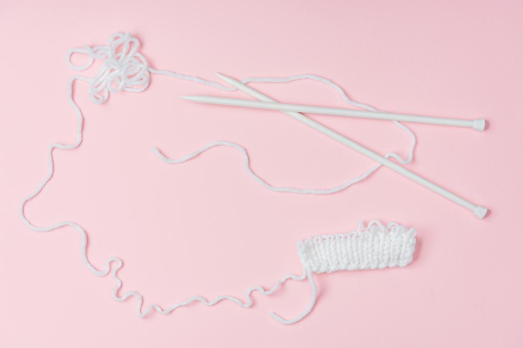 flat lay with white yarn and knitting neeldes on pink backdrop - Photo, Image