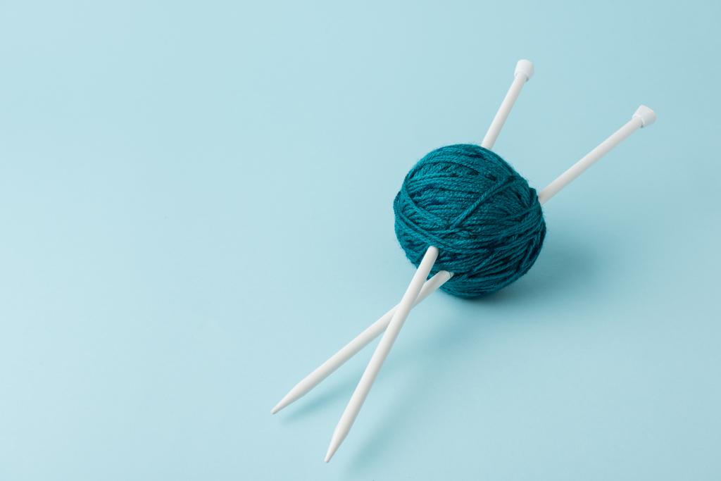 青の背景に毛糸玉と編み物のビューをクローズ アップ - 写真・画像